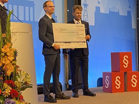 Preisträger Marco Scheel mit einem symbolischen Scheck über 50.000 Euro
