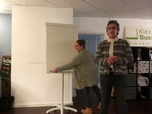 Im Bildhintergrund Laura König vom Kiez-Büro in Action bei letzten Vorbereitungen für den Vortrag