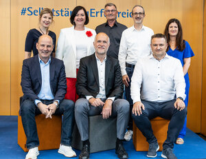 Gruppenfoto mit Redner/innen. Von oben links: Larissa Niedecken, Dagmar Rohde, Gerd Stiefel, Oliver Nowotny, Bettina Kräußlich. Sitzend: Dr. Marc Lucassen, Dr. Andreas Lutz, Dr. Klaus Wohlrabe