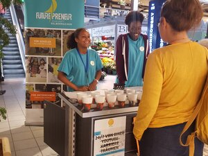 Zwei junge Futurepreneur/innen präsentieren stolz ihr Mini-Business in einem Hamburger Einkaufscenter. 