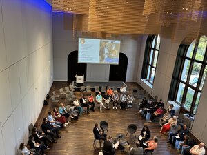 Großer Stuhlkreis rund um die "Fishbowl" mit Panel und Teilnehmer/innen - Weitere Fotos von der Veranstaltung findest du in der Galerie unten!