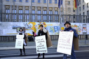 Drei Plakatträger vor dem Eingang zum Bundesfinanzministerium