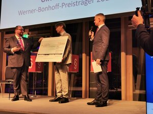 Stiftungsvorstand Till Bartelt übergibt den Preis und einen symbolischen Scheck