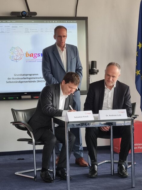 Sebastian Krauß (l.) und Andreas Lutz (r.) unterschreiben eine Kooperationsvereinbarung zwischen Mittelstandsallianz und BAGSV. 